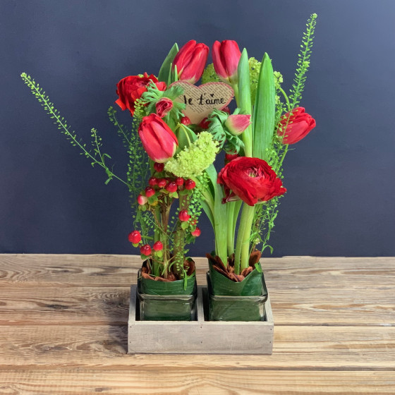 Arrangement de tulipes et fleurs printanières, dans récipient duo symbolique. Des Lys & Délices, Fleuriste à Sion